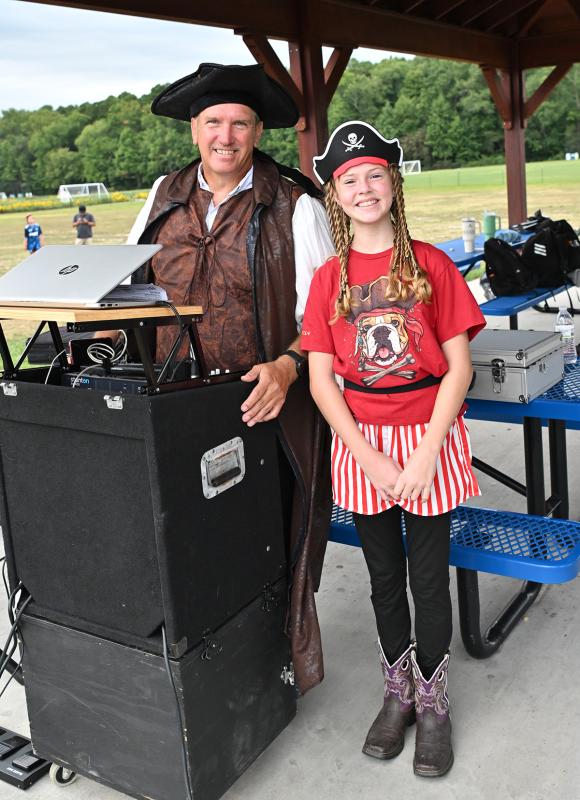 Volunteer DJ John Tomeski stands with singer Charli Evans.