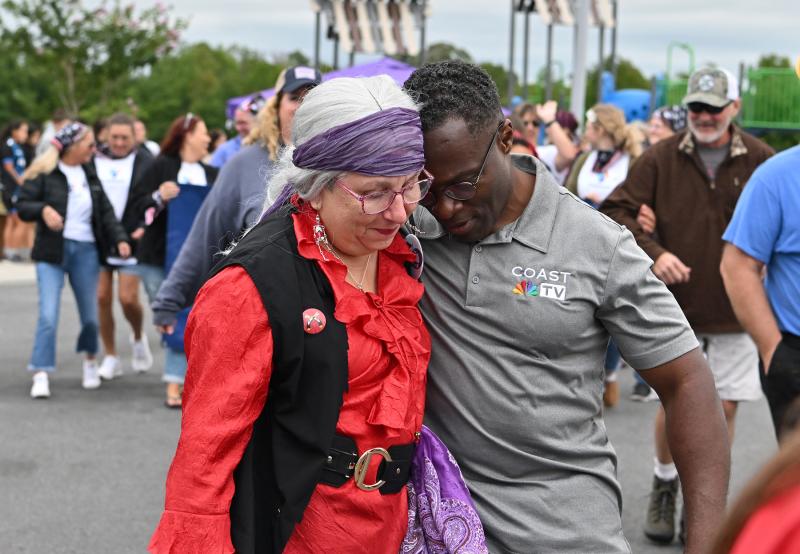 Coast TV’s Paul Williams, right, share a quiet moment with survivor Anita Ossman.