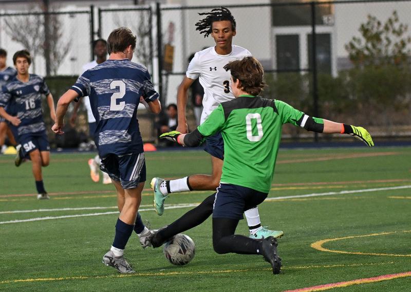 Seaford keeper Luke Metzner and Sussex Academy senior Theodore Layton battle for a ball in front of the cage.