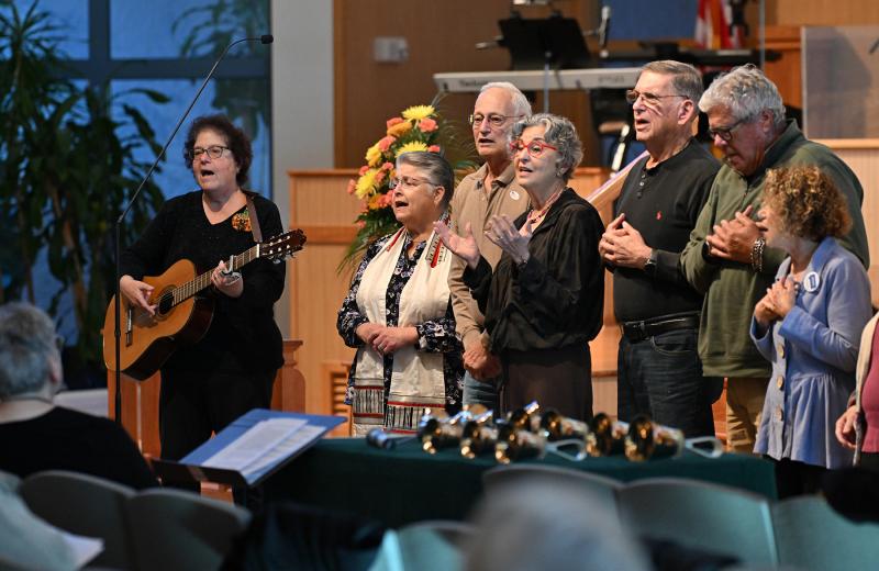 Carole Ash, leader of the Seaside Chant and Meditation Circle, plays guitar and leads the song, “We Will Build This World From Love.” DAN COOK PHOTOS