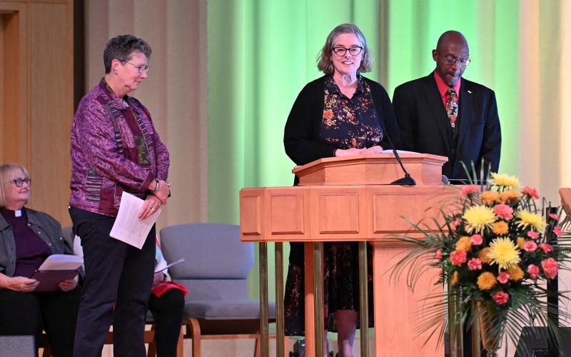 The Rev. Heather Rion Starr from the Unitarian Universalists of Southern Delaware reads the prayer “Let Us Learn Peace” with Eli Scearce, left, and Ralph Gooch.