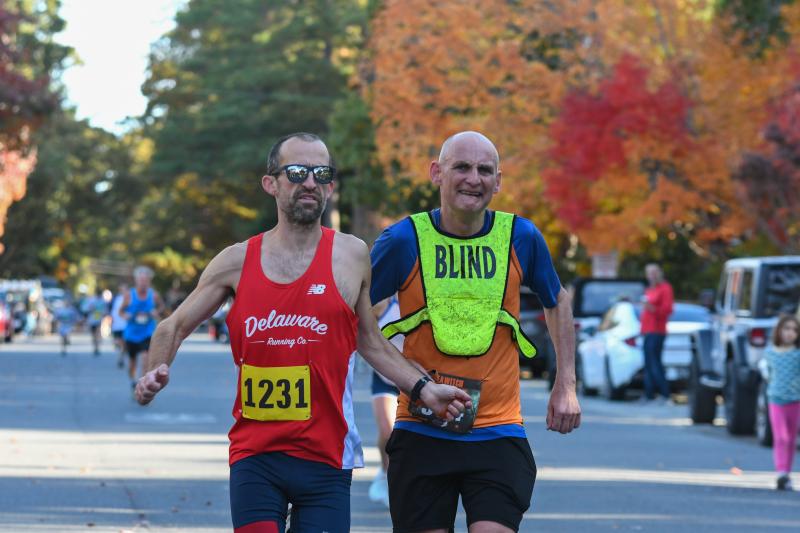 Anthony Swierzbinski and Ian Fleming run the 5K tethered together.