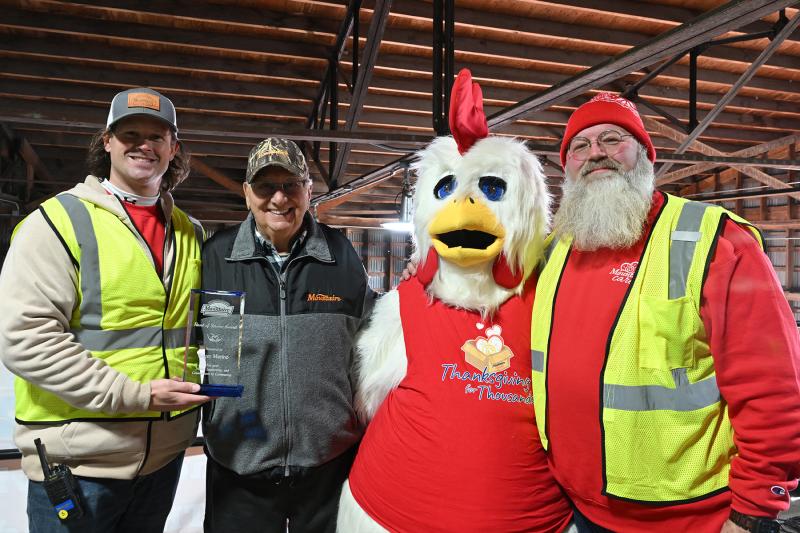 On hand for the presentation of the Heart of Service Award are (l-r) Zach Evans, senior Mountaire Cares manager; Roger Marino, award recipient; the Mountaire chicken mascot; and J.R. LaPearl, director of Mountaire Cares. Marino was one of the event founders and has been a volunteer for 30 years.