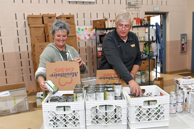 Charlotte Williams, left, and Mike Thomas fill the vegetable boxes for the giveaway.