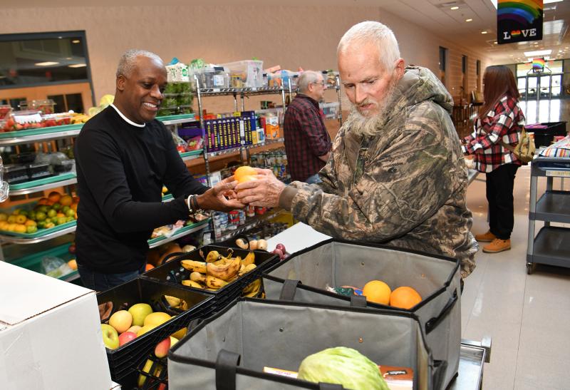 Donald Spray chooses some healthy vegetables from Epworth’s Hubie Brown during the food basket giveaway. DAN COOK PHOTOS