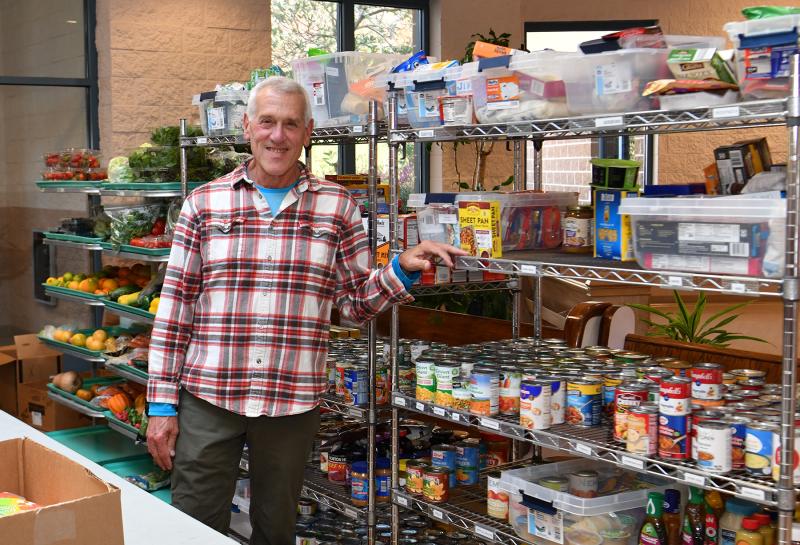 Goods Samaritan Ministry leader David Streit poses with the racks of free food.