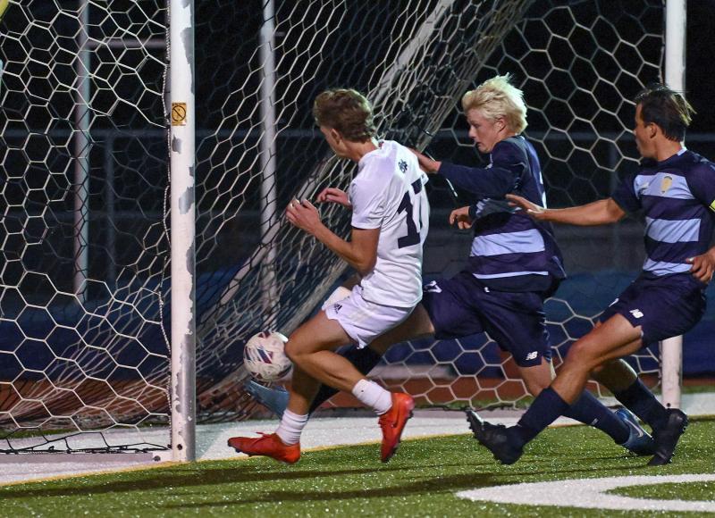 Sussex Academy junior Chase Ballinger squeezes the ball in the corner of the cage to score the game-winning goal.