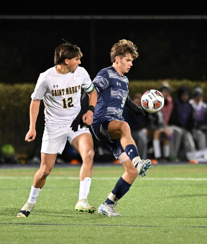 Sussex Academy junior forward George Sapna keeps possession away from Saint Mark’s Brian McDermott.