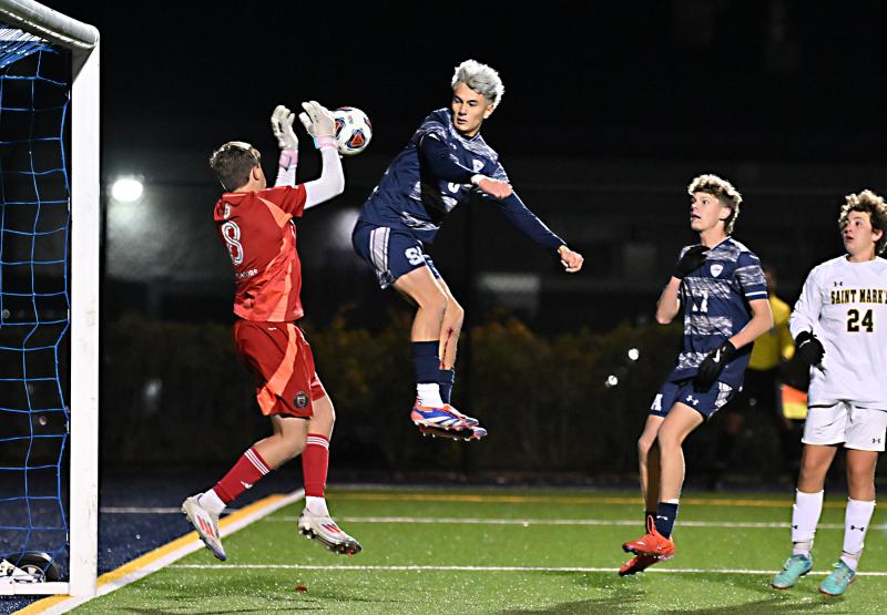 Saint Mark’s keeper Tom Swasey makes a save as Sussex Academy senior Aiden Villar looks for a rebound.
