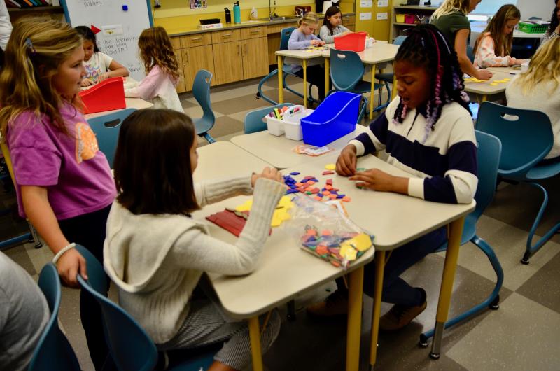 Charlotte Schlitter, left, and Bryia McCrea discuss what they are constructing as Lucy Tyron puts the finishing touches on the first build.