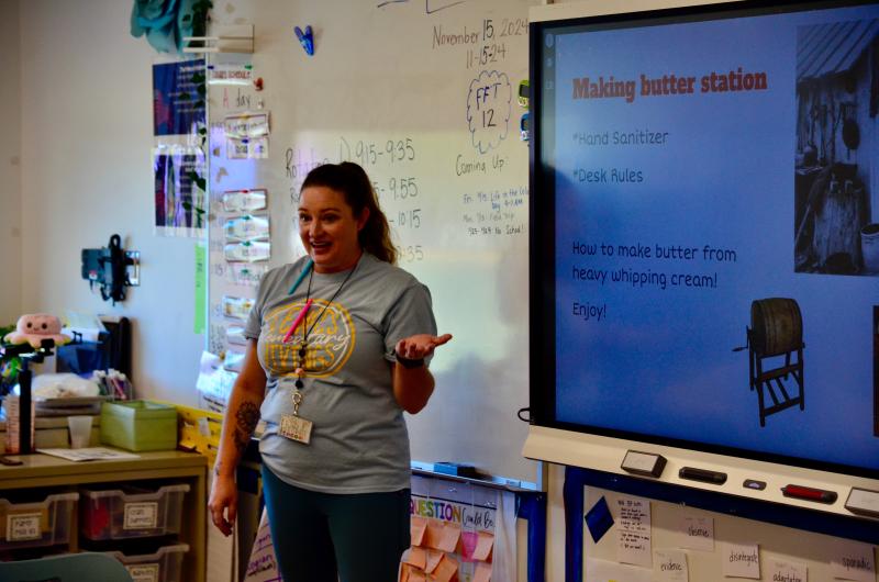 Katie McDermott explains to the students that children had to pitch in around the house, with no allowance, so the family could have their clothes washed and things like butter to enjoy.