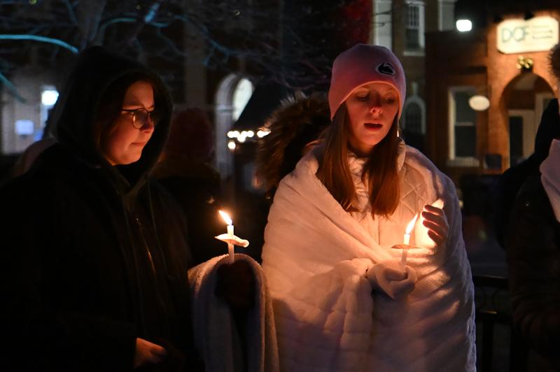 Emily James, left, and Addison Light sing “Silent Night” during the candlelight service.
