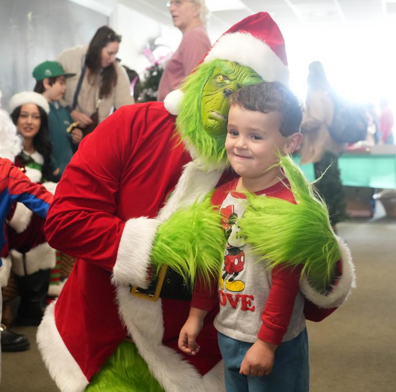 Layton Kenton, 3, stands with the Grinch at this year’s Trees of Cheer.