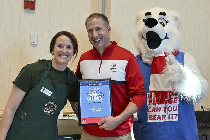 Gretchen Lauer of Woodside Farm Creamery receives an award for the best ice cream from David Halley, president and CEO of Special Olympics Delaware, and Lewie P. Bear.