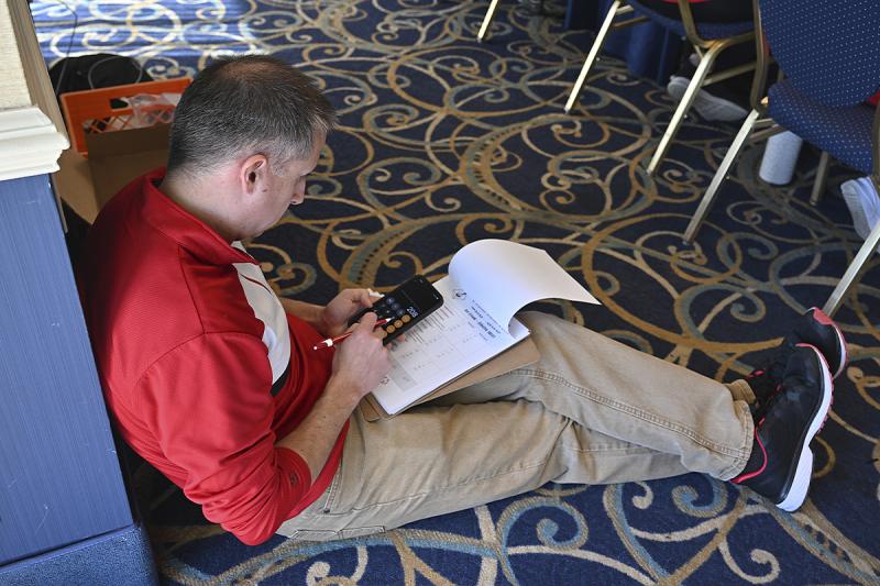 Special Olympics Delaware CEO and President David Halley takes a rare break from running around to tally the votes for the hot wing and ice cream competitions.