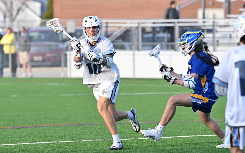 Cape senior Evan Burris looks to pass to teammate Ryan Morgan on the crease.