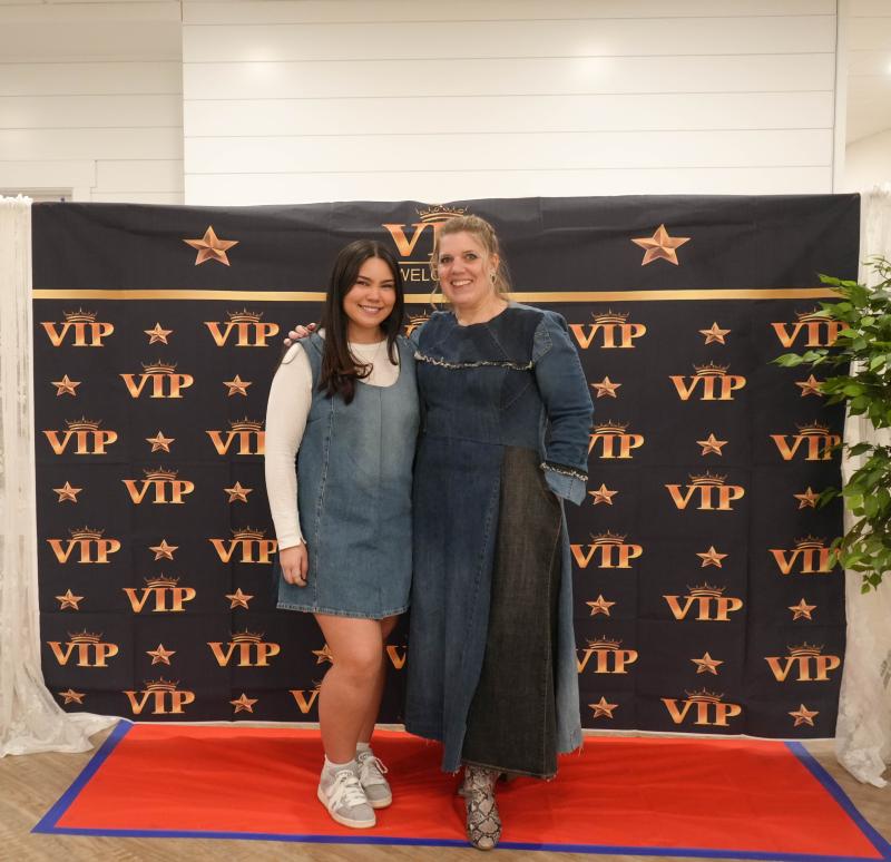 Val Imperial, left, a junior, stands with teacher Alayna Aiken. Imperial, modeling a dress that she made from the legs of a pair of jeans, came up with the idea for the Feb. 22 fashion show.