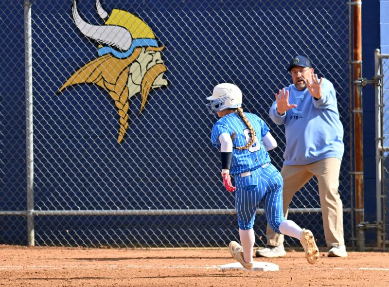 Cape head coach Mike Tkach holds up Ava Calciano at third.