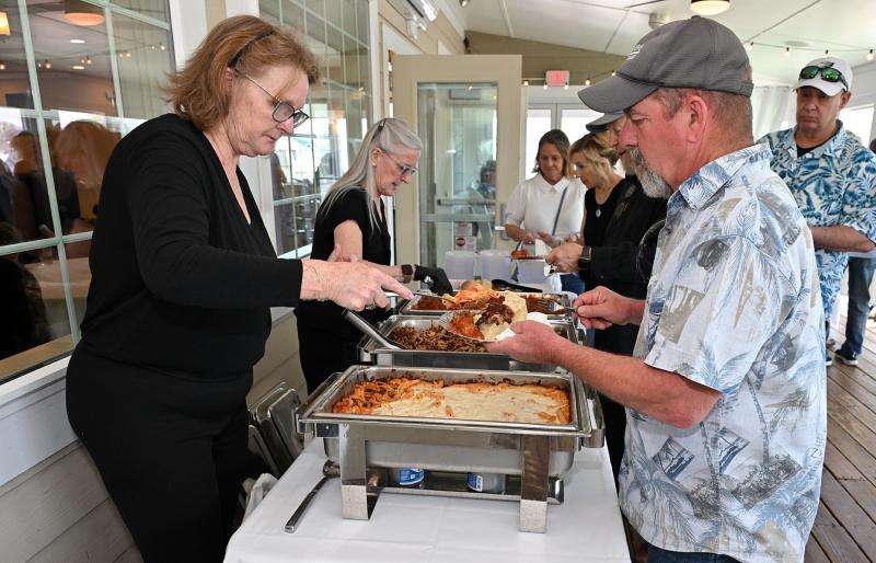 Mick Olinderski, right, gets some delicious food from Colleen DeShazo, left, and Carol Easley.