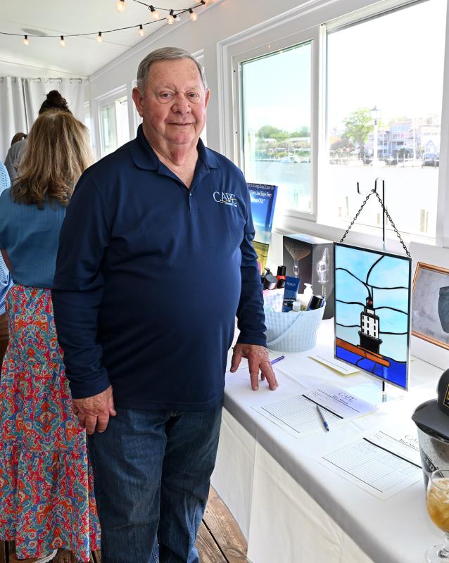 CCF board member Butch Archer stands with a stained-glass lighthouse suncatcher he made and donated to the silent auction.