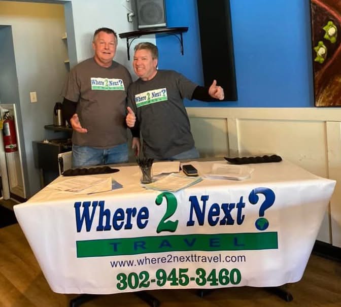Working the Where 2 Next? Travel table at a previous fundraiser are Bob Robinson, left, and owner Frank Echols.