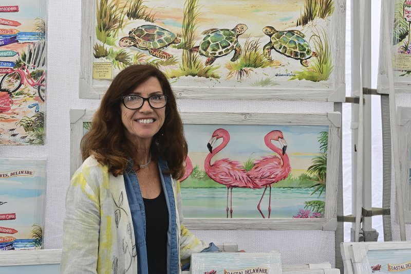 Artist Donna Elias stands in front of her works.