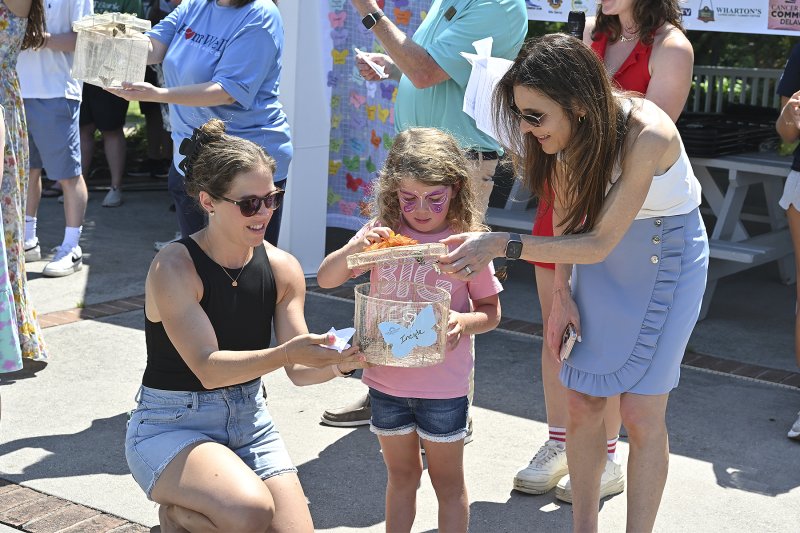 Alexander Meyer and her daughter are assisted by Nichole Topkis Pickles, executive director for the CSC of Delaware, during the release of the butterflies.