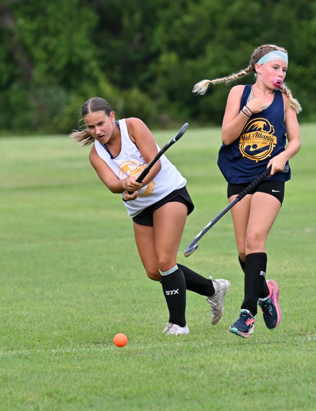 White team camper Brenna Shelly slams the ball upfield past during the Blue team’s Steve Young.
