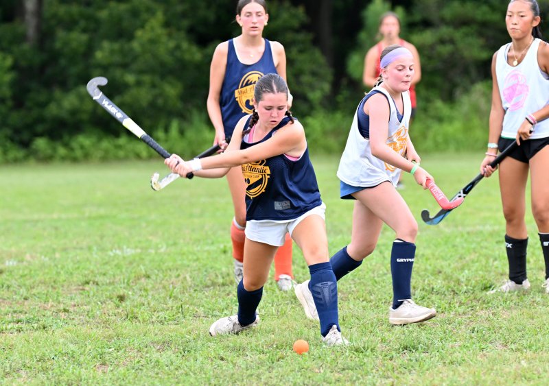 Blue team’s Maddie Weiss takes a shot past White squad’s Olive Leshock.