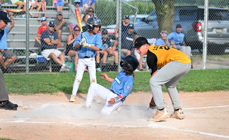 Austin Coulter slides under the tag attempt by Georgetown’s Donald Lewis.