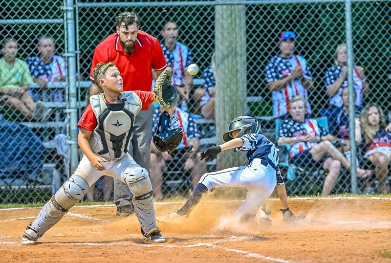 Milton’s Henry Hill slides safely into home.