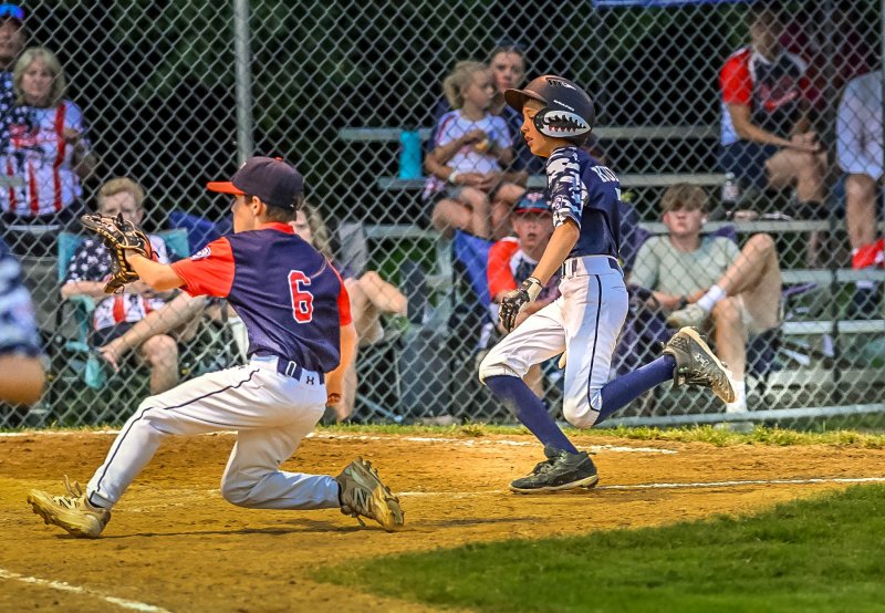 Milton’s Jaxon Kulp scores on a passed ball.