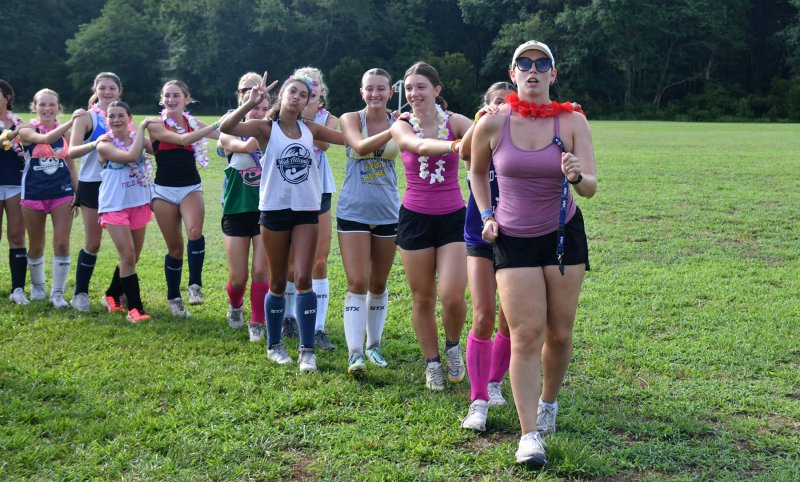 Coach Grace Walsh leads her group in a conga line during warmups.