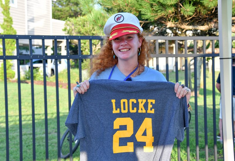 Fallon Hoffman displays a Locke 24 shirt as she works the swag table for the event.