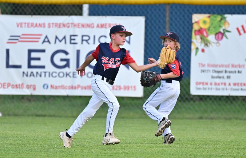 MOT left fielder Jack Chambers makes a catch in front of his teammate Reid Bailey.