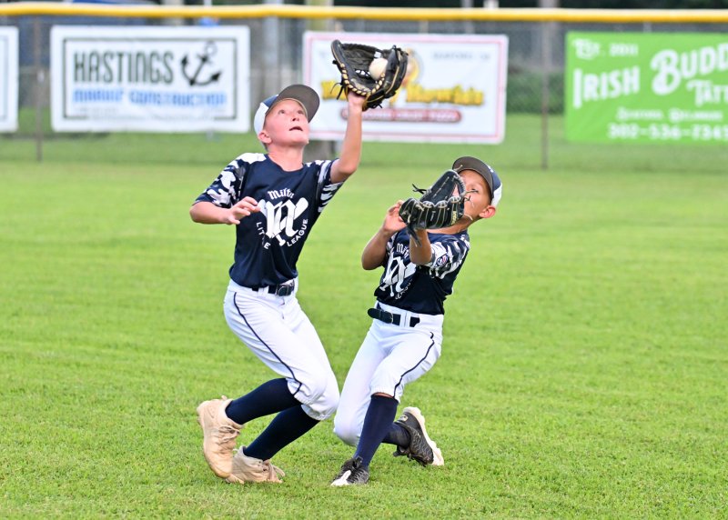 Milton’s Jacob Reynolds catches the fly ball and avoids a collision with outfielder Roman Schlezes.