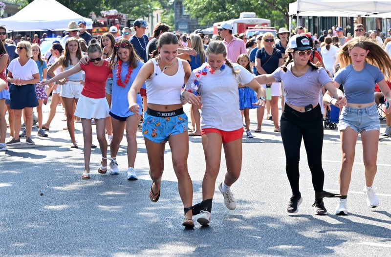 The teens flew down the street in the three-legged race.