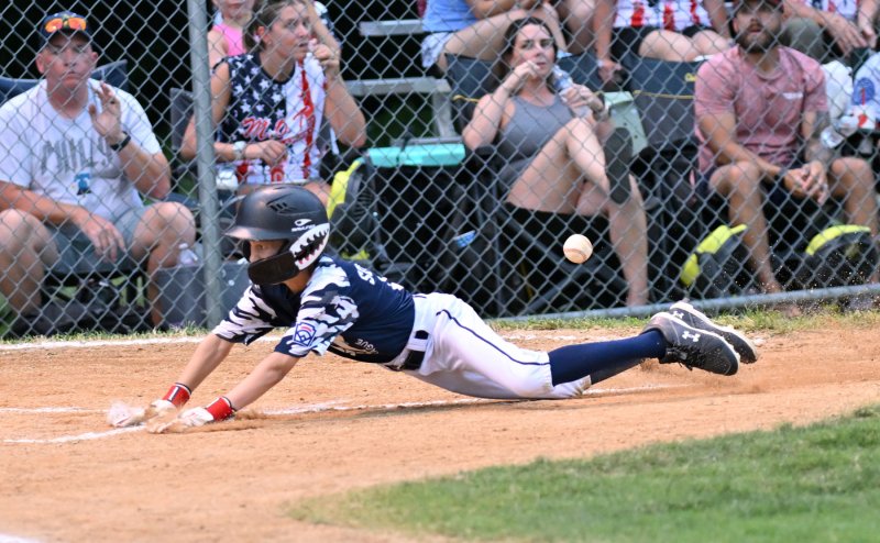 Milton’s Michael Sockriter slides safely into home.