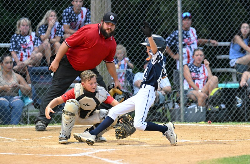 Milton’s Henry Hill avoids the tag by MOT catcher Lochlyn Jones for a score.