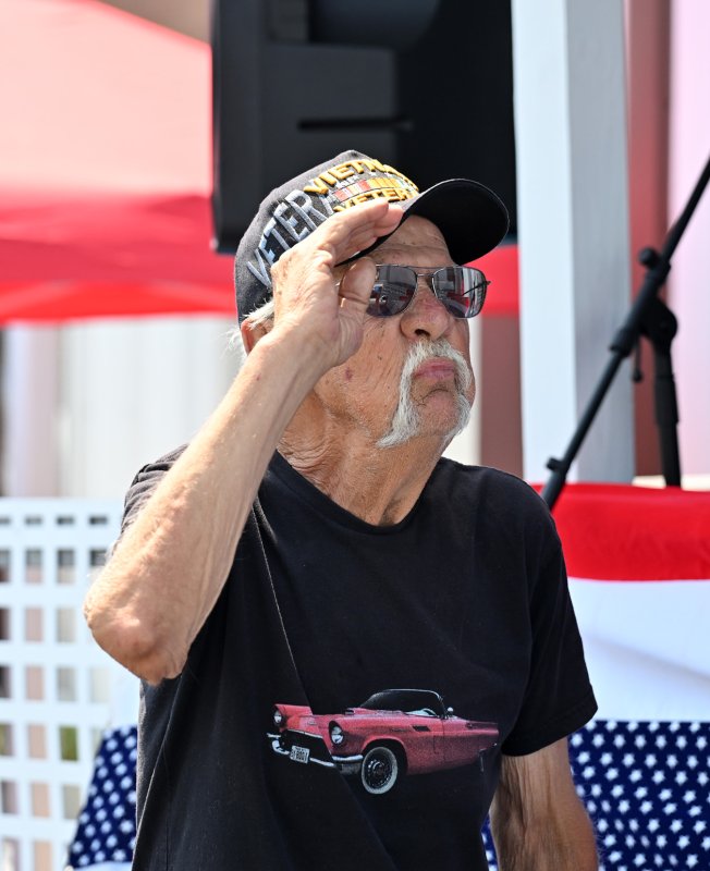 Vietnam vet Frank Palermo salutes the flag as DJ 1Luv (Arthur Jones) plays the national anthem.