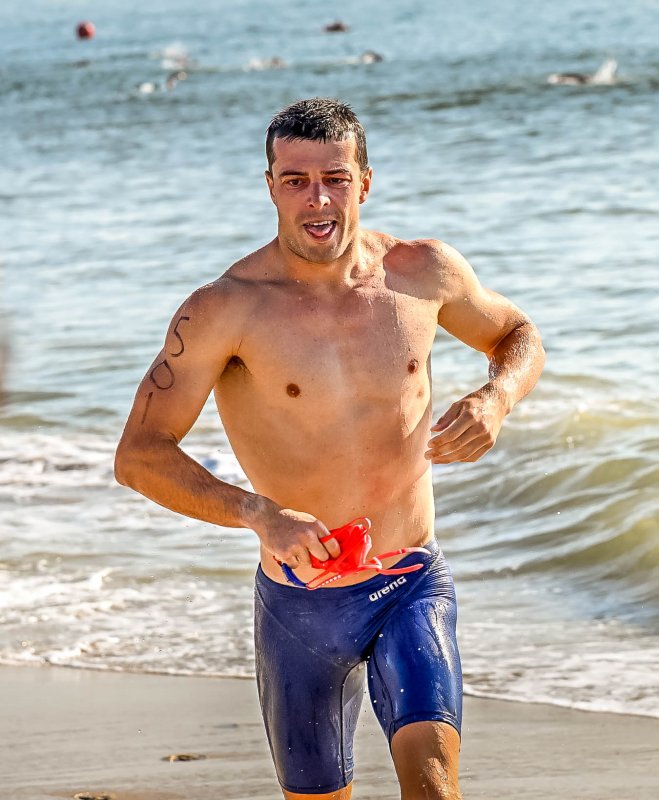 Male winner Sean Saxton leaves the surf to start the run.