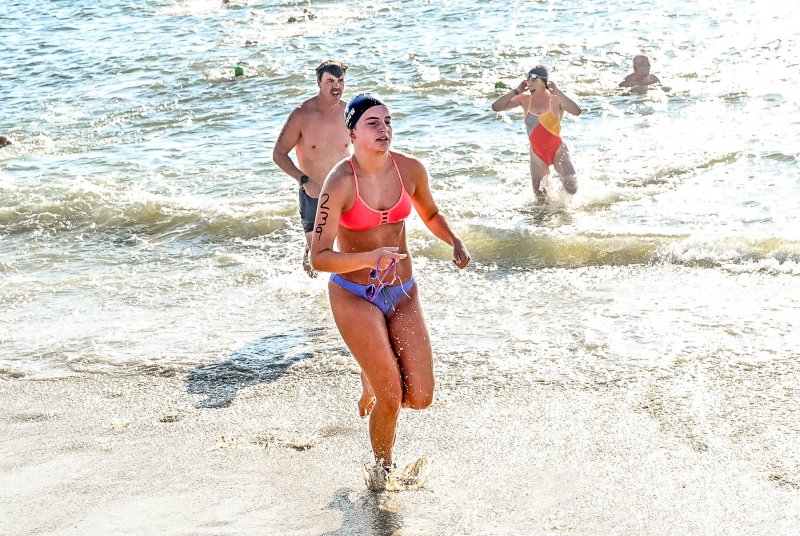 Cape swimmer Isla Touw leaves the surf after the swimming leg of the biathlon.