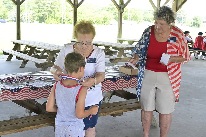Tucker Mood is presented with the third-place ribbon and award for most patriotic attire by June Jones, president of American Legion Auxiliary Unit 28, and Beth McGinn, auxiliary vice president.