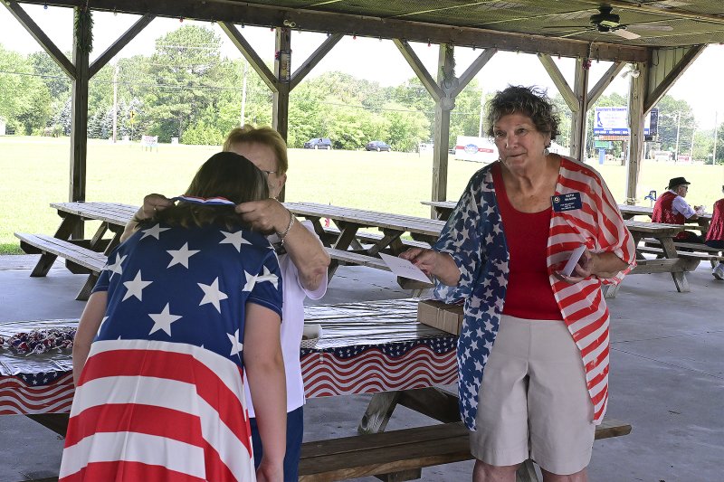 Makenzie Mood is presented with the second-place ribbon and award for most patriotic attire by June Jones, president of American Legion Auxiliary Unit 28, and Beth McGinn, auxiliary vice president.