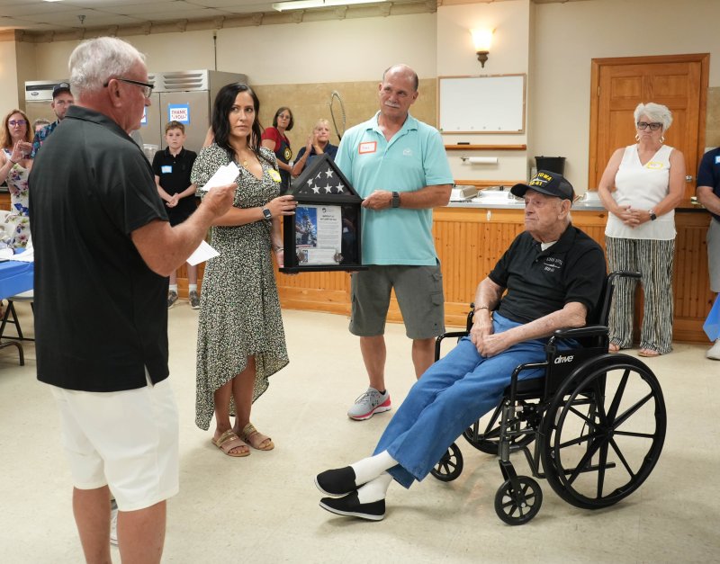 Raymond Sproul is presented with the flag that was flown on the U.S.S. Iowa, the ship he was serviced on in the late 1940s during his time in the U.S. Navy. Those presenting the flag to him are (l-r) Bill Easton, his nephew and an Army veteran; Jenny Pratt, his great niece and a Navy veteran; and Ray Uroda, a Coast Guard veteran who’s married to Raymond’s niece Patty.