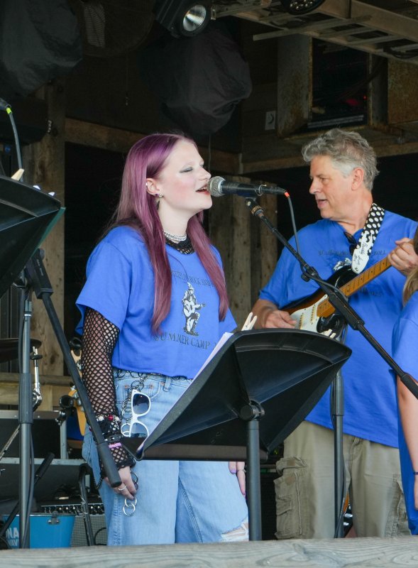 Lorilyn Marsch sings “Zombie” by The Cranberries. To her right, Walt Hetfield plays the guitar.