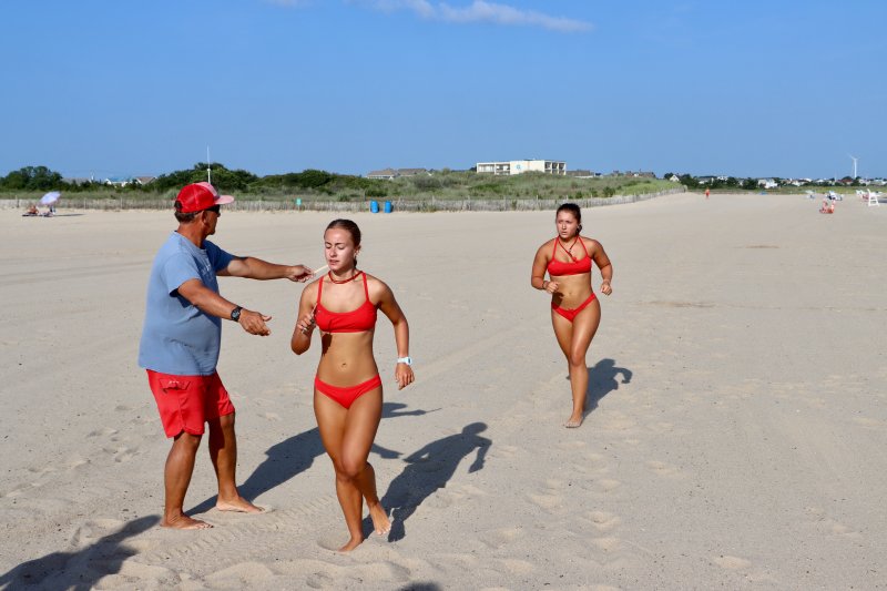 Savannah Couch and Sarah Bieler cross the finish line at the end of the beach sprint at Johnnie Walker Beach.