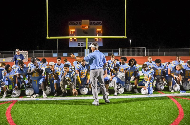 Coach Chip Knapp speaks with his players after winning his first game with the Vikings.