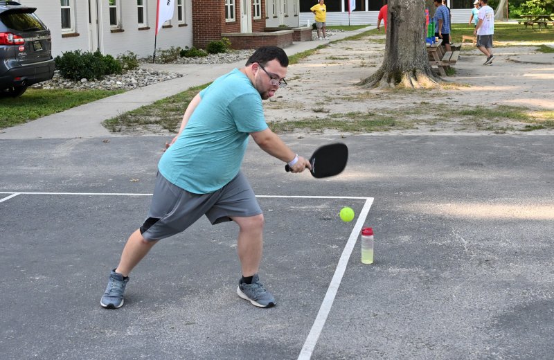 Athlete Matthew Beck goes out wide for a shot during his pickleball match.