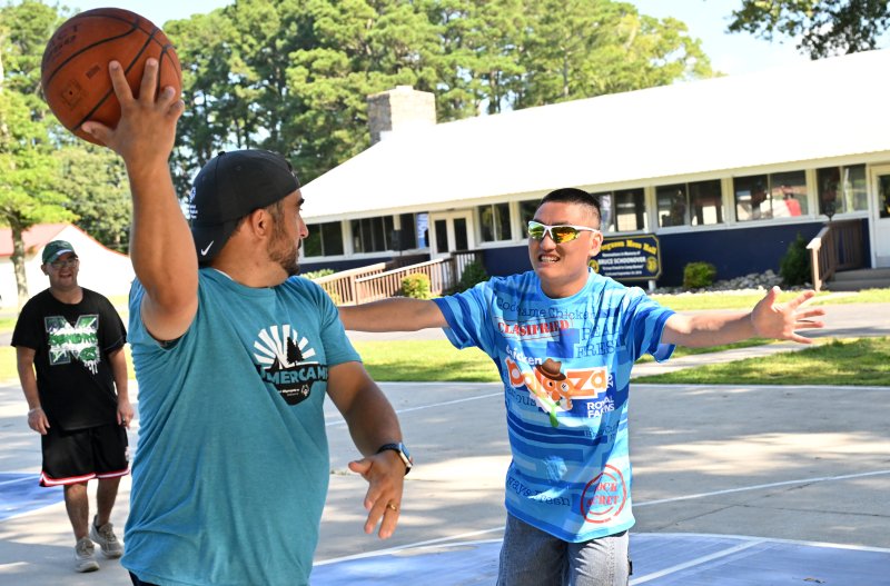 Senior Director of Sports & Competition Ben LoPresto, left, makes a back pass to his teammate to fake out athlete Asa Mebane.